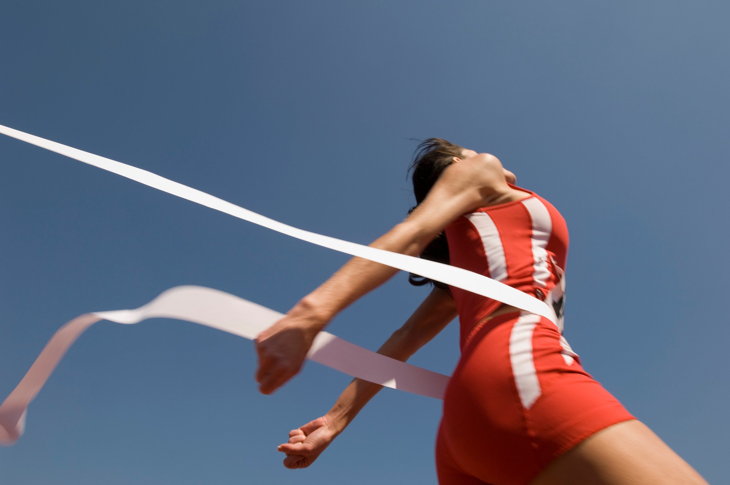 Female track athlete crossing finishing line